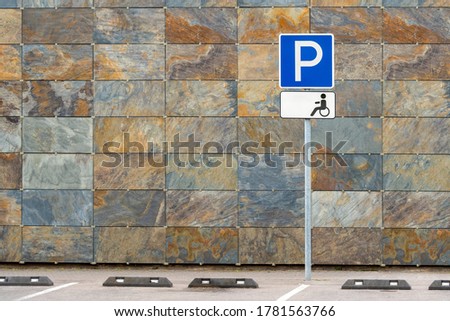 Blue sign showing the parking lot is reserved for disabled