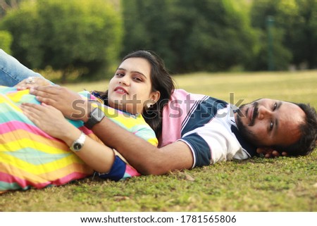 Indian pregnant lady with husband in park. Maternity photo shoot concept.