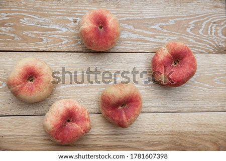 ripe peaches on 
light colored wooden table