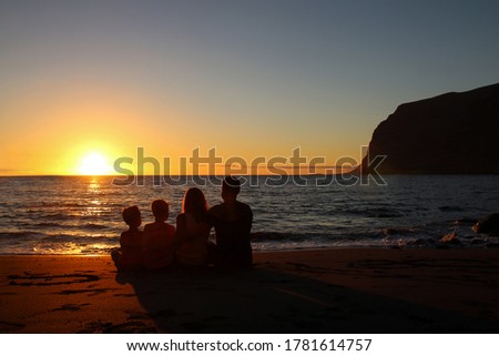 Happy family silhouette. Family silhouettes on the beach. Parents with childs in sea on sunset
