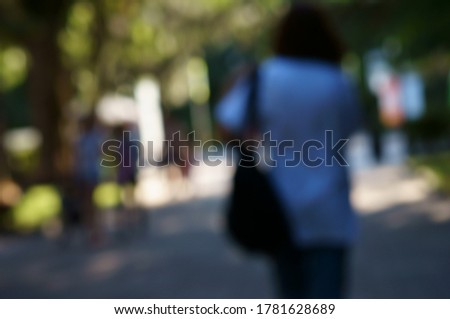 Blurred background. A group of people walking in a recreation Park.