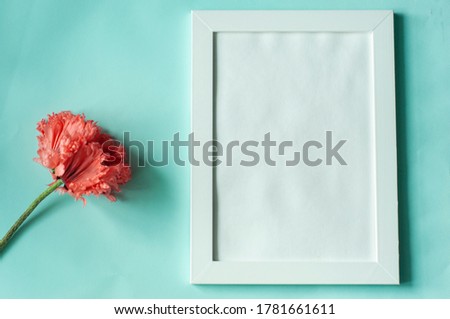 White empty frame mock up on light green background and pink poppy flower