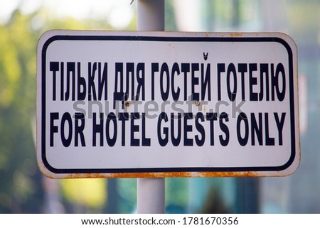 Close-up For hotel guests only sign in English and Ukrainian, selective focus
