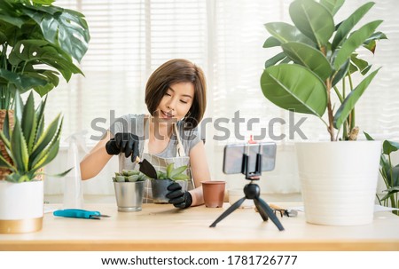 Portrait of young asian woman planting plant pot to fan channel record home video Online influencer girl in social media marketing live blog hobby new normal sme small business, sustain ecology