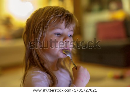 little girl eating cookies and milk while watching cartoon