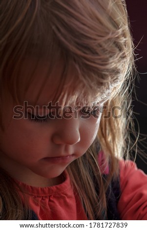 image of a child from the profile while she is playing the game, note shallow depth of field