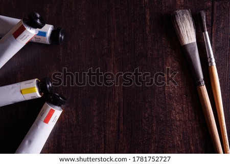 Artist paint brushes and paint on wooden table