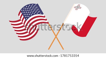 Crossed and waving flags of Malta and the USA