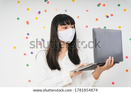 Beautiful asian thai long dark hair woman wearing white surgical mask using laptop isolate over white party background. Work from home concept. Business woman working with computer laptop.