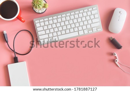 Pastel pink desk office with laptop, smartphone and other work supplies with cup of coffee. Top view with copy space for input the text. Workspace on desk table essential elements on flat lay.
