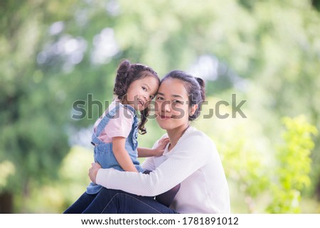
Portrait of a happy mother with her daughter in an outdoor public park, Asian girl lifestyle, Asian Mother's Day concept