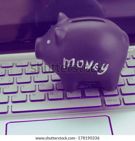 internet shopping concept - black piggy bank on laptop keyboard