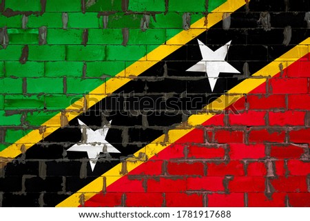 The national flag of Saint Kitts and Nevis painted on a wall of sibit blocks with cement . The symbol of the country.