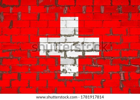The national flag of Switzerland painted on a wall of sibit blocks with cement . The symbol of the country.