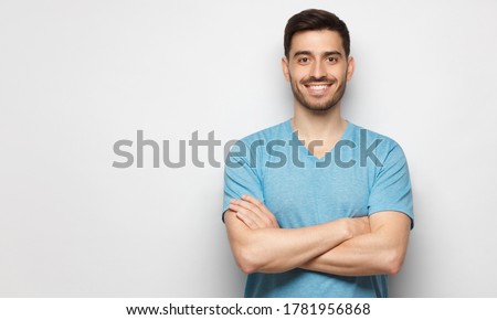 Banner of young handsome man wearing blue t-shirt, standing with crossed arms, isolated on studio gray background Royalty-Free Stock Photo #1781956868
