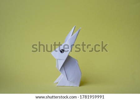 Simple flat lay out. White rabbit paper origami on clear background with copy space concept