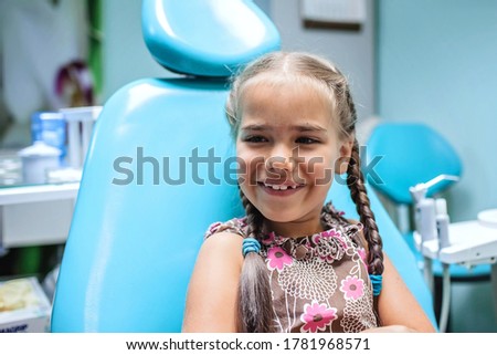 Cute girl having fun and sitting with open mouth during her visit to dentist office. Healthy teeth and painless treatment, pediatric dentistry concept Royalty-Free Stock Photo #1781968571