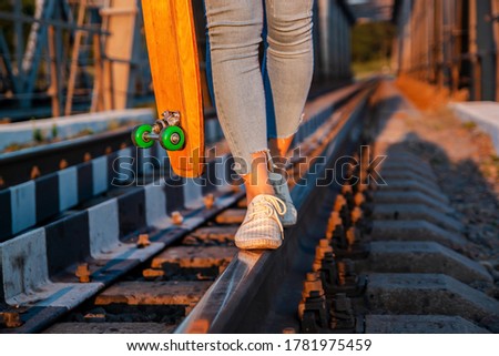 Photo Of Legs Of Girl In White Shoes With Skateboard on the railway