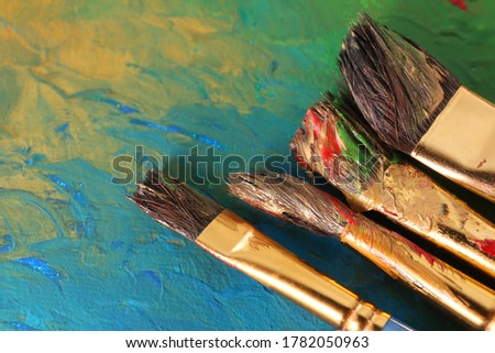 Abstract colorful artwork and brushes, closeup view