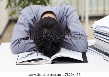 	A man looks stressed as he works at his desk	