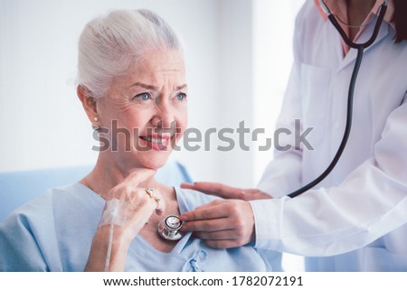 Happy Elderly patient talk with woman doctor at room in hospital. Doctor use stethoscope listening lung of elderly patient. Healthcare homecare concept
