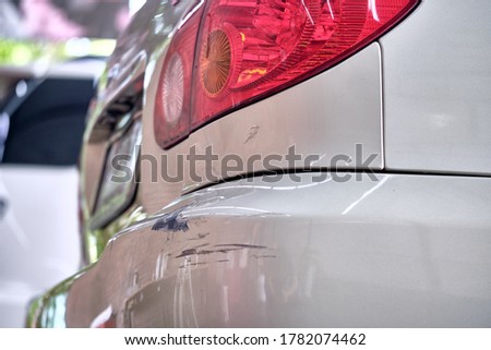 Paint scratches on car bumper with paint damage from car crash. Close up of car dent and paint cracked & peeling. Car accident & insurance claim concept. Paint repair garage background. Royalty-Free Stock Photo #1782074462