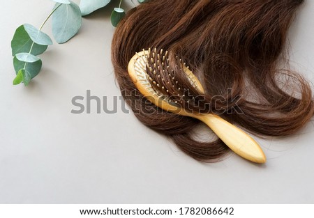 female hair,  bamboo comb, eucalyptus leaves on beige background top view, flat lay. copy space. Self care, hair treatment  concept. Royalty-Free Stock Photo #1782086642