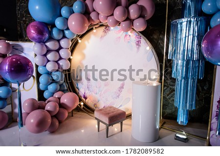 Pink photo zone with balloons, chair and cake on birthday party