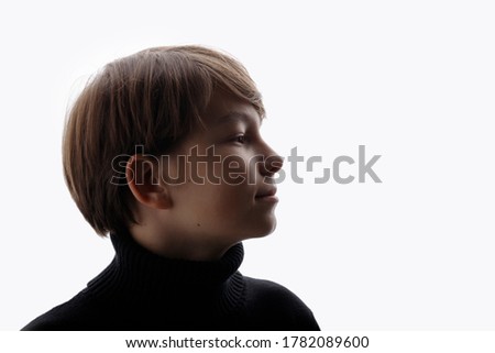 Portrait of teenager on white background. Beautiful young boy in profile. Free space for text.