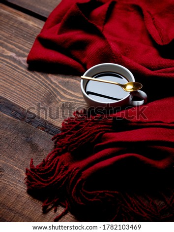 Cup of coffee and cookies with scarf on wooden table