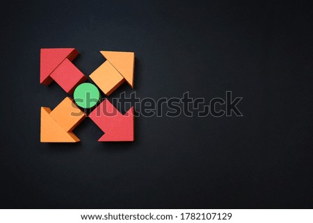 Colorful arrows from blocks pointing different directions and laptop on black background 