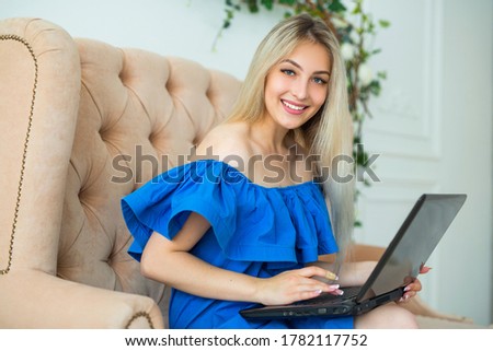 beautiful young female with loose hair on the sofa with a laptop