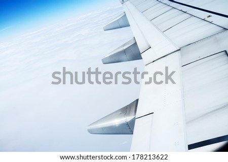 The plane's wings, the background is blue sky, taken from the cabin Royalty-Free Stock Photo #178213622