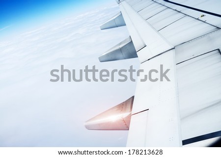 The plane's wings, the background is blue sky, taken from the cabin Royalty-Free Stock Photo #178213628