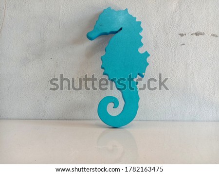 seahorse-shaped wall hangings isolated on a gray background wall
