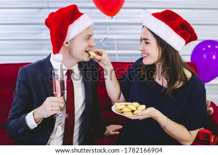 Happy new year 2021 concept,Happy couple Hold a glass of champagne and eat the cookies in Christmas and New Year's Eve party After finishing business work 