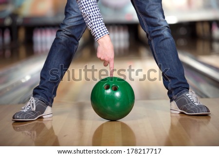 Cheerful young man playing bowling