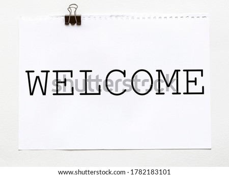 white paper with text WELCOME on a white background with stationery