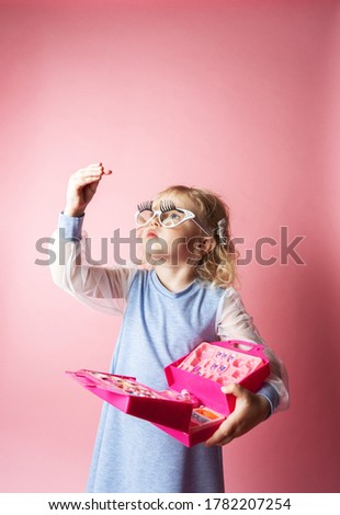 Little girl child plays with a set of children's cosmetics.
