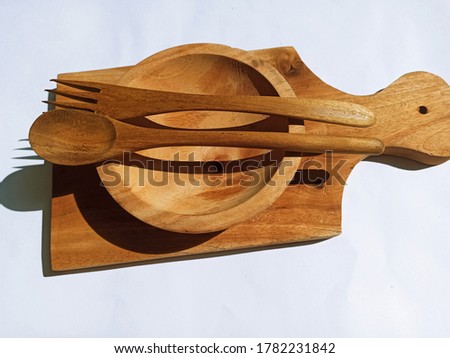 Wooden cutting boards, wooden plates, insulated wooden cutlery against a white background.