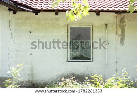 Reflection of zugspitze mountain on house glass window with nature reflection, old home exterior view. reflection of Zugspitze (Wettersteingebirge) Mountain in window with curtains in an old building