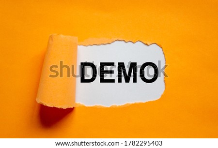 The word 'demo' appearing behind torn orange paper. Business concept. Copy space. Royalty-Free Stock Photo #1782295403