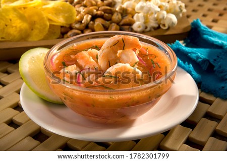 Ecuadorian shrimp ceviche is a very popular dish in Ecuador. It's a cold soup with shrimp, with fresh tomato, lime and a bit of orange juice. Served with fried plantains, popcorn and toasted corn. Royalty-Free Stock Photo #1782301799