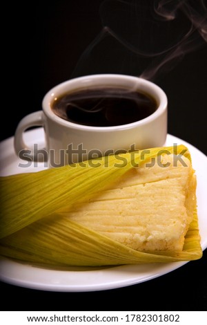 Steamed fresh corn cake in a leaf, called "Humita", is a traditional and popular Ecuadorian dish. Accompanied by a cup of hot black coffee. Royalty-Free Stock Photo #1782301802