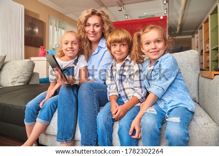 Happy family life at home. A mother spends time with her children using  PC tablet at home.