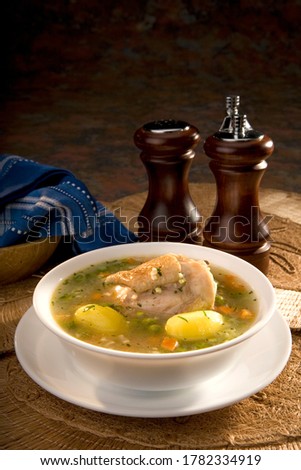 Ecuadorian chicken soup, or "caldo de gallina", is a popular dish in Ecuador. It's served with potatoes, peas and carrots. Food still life. Royalty-Free Stock Photo #1782334919