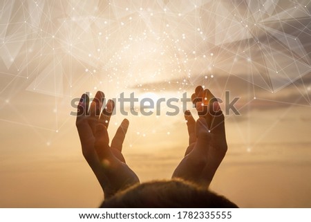 The concept of integration network . Hands is in contact with a virtual network on a background of sunny sunset.