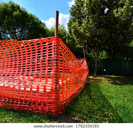 Plastic safety construction fence. Perforated plastic foil preventing entry to an playground. Safety and protective foil with oval holes.  High security. Building barrier.