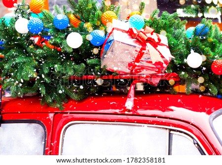 Christmas background. Fir tree with garlands and gift box on red car.
