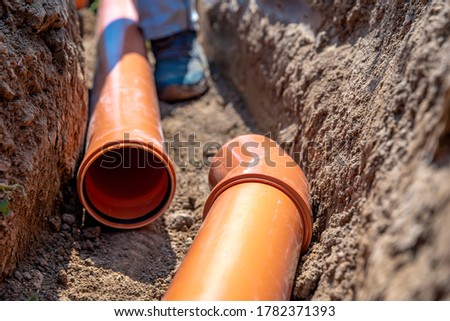 laying drainage pipes into the ground Royalty-Free Stock Photo #1782371393